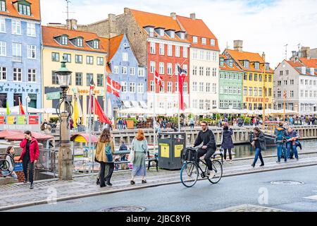 Kopenhagen, Dänemark - 23 2022. Mai: Radfahrer, Fußgänger und Touristen in Christianshavn Nachbarschaft, Kopenhagen, Dänemark mit traditionellen Häusern Stockfoto