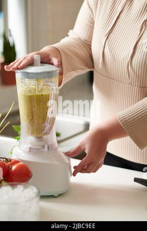 Frau, die Zutaten für einen gesunden Fruchtmoothie mischt Stockfoto