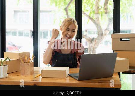 Asiatische Frau denken hart arbeiten Laptop-Computer zu Hause verkaufen online Start-up-Kleinunternehmen Eigentümer, E-Commerce-Ideen-Konzept Stockfoto