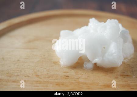 Kaltes Kokosöl auf Holzbrett, Stockfoto