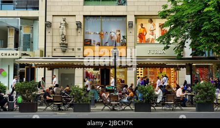 Die berühmte Luxus-Einkaufsmeile Königsallee in Düsseldorf mit Straßencafé an einem Sommertag. Stockfoto