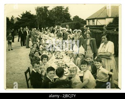 Original-Familienfoto aus dem Jahr WW2 von der Straßenparty für Kinder in einem Vorort zur Feier des Sieges über den Japan Day (V.J. Day). Danach sollte ein Lagerfeuer angezündet werden, auf dem die Bildnis von Hitler und Mussolini zu sehen war. Der 15. August ist der offizielle V-J-Tag für das Vereinigte Königreich, während der offizielle US-Gedenktag der 2. September ist. Diese Straßenparty fand 2 Tage später an einem Freitag statt, datiert vom 17. 1945. August, Großbritannien Stockfoto