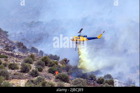 Athen, Griechenland, 4. Juni 2022: Ein Hubschrauber vom Typ McDermott Aviation Bell 214B wird in einem Waldfeuer auf dem Hymettus-Berg in der Nähe des Vororts Glyfada in Athen eingesetzt. Stockfoto