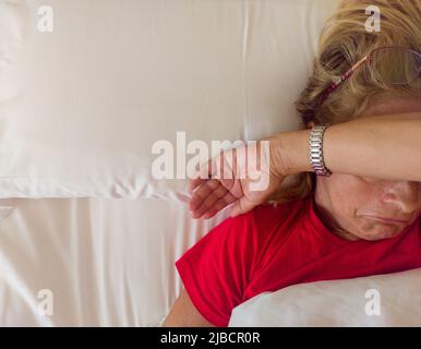 Traurige Frau im Bett liegend Stockfoto
