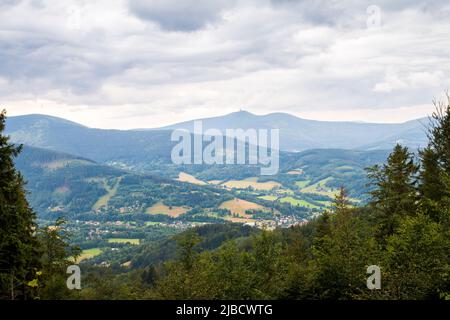 Blick auf den Lysá hora Berg und ein Tal, das an einem heißen Sommertag von Sonnenlicht durchflucht wird Stockfoto