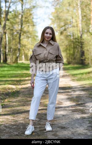 Mädchen in einer Jacke zu Fuß im Park. Stockfoto