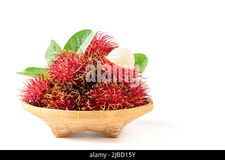 Frische Rambutan-Früchte auf Bambuskorb isoliert auf weißem Hintergrund. Frucht Südostasien. Rambutan ist sehr nahrhaft und kann gesundheitliche Vorteile bieten Stockfoto