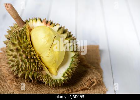 Frischer Durian (Monthong) auf Sack und altem Holzhintergrund, König der Früchte aus Thailand in der Sommersaison Stockfoto