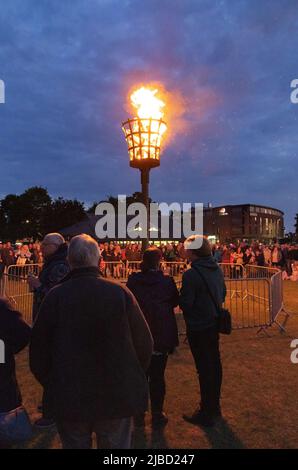 Queens Platinum Jubilee Beacon leuchtet, Menschen beobachten das Leuchtfeuer, das in der Abenddämmerung auf den Severals brennt, Newmarket Suffolk UK Stockfoto