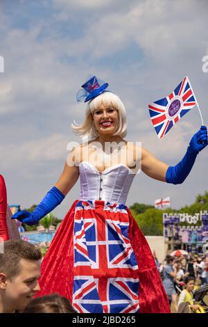 Queen Elizabeth Platinum Jubilee; Junge Frau in britischem Kostüm auf Stelzen bei den Platinum Jubilee Feiern, Newmarket, Suffolk UK Stockfoto