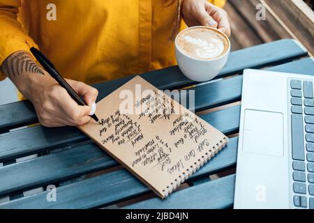 Junge Frau, die in Notizbuch-Self-Care-Ideen-Liste für den Geist, die Seele, den Körper schreibt Stockfoto