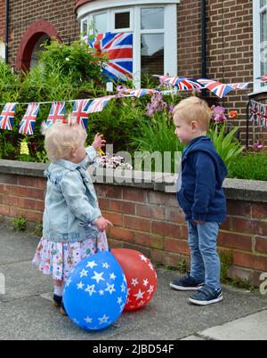 Stockton-on-Tees, Großbritannien. 05 Juni 2022. Die Bewohner der Waltham Avenue, Fairfield, veranstalteten eine Straßenparty zur Feier des Platinum Jubilee of her Majesty Queen Elizabeth II., was die rekordbrechende 70-jährige Regierungszeit von her Majesty markierte. Hier inspizieren zwei der jüngeren Bewohner die Ammer. Quelle: Teesside Snapper/Alamy Live News Stockfoto