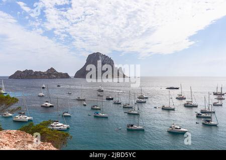 Mittelmeer, weiße Katamarane und Yachten verschiedener Größen und Arten sind in der Bucht Cola d'Hort vor Anker. Ibiza, Balearen, Spanien Stockfoto