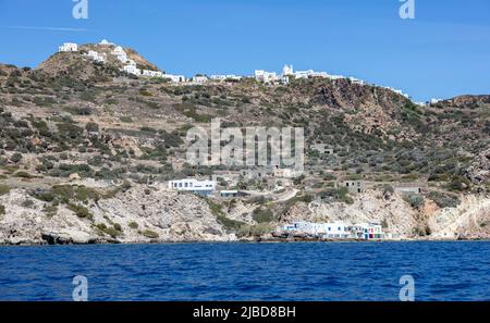 Kykladen Griechenland. Insel Milos, traditionelle Gebäude an der Küste und Stadthäuser bergauf. Häuser am Wasser mit bunten Türen und Fenstern, Blick aus Stockfoto