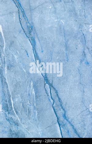Ungewöhnliche Textur aus rauchblauem Marmor mit diagonalen Adern und Rissen. Vertikales Bild. Stockfoto