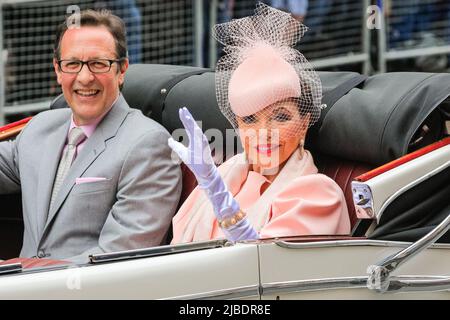 London, Großbritannien. 05.. Juni 2022. Die Schauspielerin Dame Joan Collins und ihr Ehemann Percy Gibson lächeln und winken aus ihrem offenen Oldtimer. Der Platinum Jubilee Pageant umfasst 10.000 Teilnehmer in vier Akten, „für die Königin und das Land“, eine Militärparade, „die Zeit unseres Lebens“, die die 7 Jahrzehnte der Regierungszeit der Königin zeigt, darunter 150 „nationale Schätze“-Prominente und feiern Kultur, Musik und Mode, „Let's celebrate“, Und „Happy and Glorious“, die endgültige Form vor dem Buckingham Palace. Kredit: Imageplotter/Alamy Live Nachrichten Stockfoto