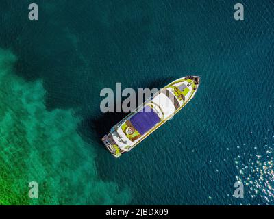 Luftdrohne Top-Down-Ultra-Wide-Foto von Luxusyacht in tropischer exotischer Inselbucht mit kristallklarem türkisfarbenem Meer verankert. Stockfoto