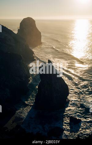 Klippen in Miradouro da Praia do Caneiro bei Sonnenuntergang, Atlantik, Portugal. Stockfoto