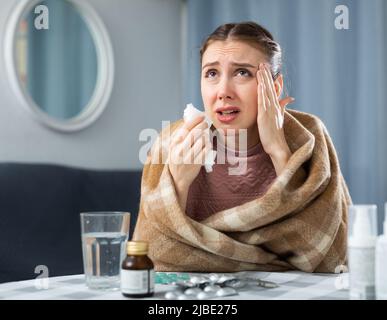 Kranke Frau, die zu Hause an Kopfschmerzen leidet Stockfoto