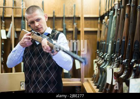 Porträt des Kunden, der Kampf Gewehrgewehr in Armee-Markt zu wählen. Stockfoto