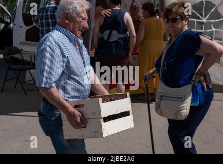 Terrades, Spanien. 05.. Juni 2022. Ein älterer Mann wird gesehen, wie er zwei Kisten voller Kirschen trägt. Nachdem die XXV Fira Mercat de la cirera (Kirschenmesse) wegen Covid-19 für zwei Jahre in Folge ausgesetzt wurde, fand sie wieder in Terrades, Girona, statt. Kredit: SOPA Images Limited/Alamy Live Nachrichten Stockfoto