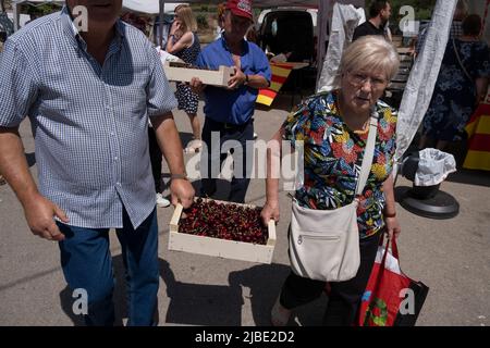 Terrades, Spanien. 05.. Juni 2022. Man sieht, wie die Menschen eine Kiste Kirschen tragen. Nachdem die XXV Fira Mercat de la cirera (Kirschenmesse) wegen Covid-19 für zwei Jahre in Folge ausgesetzt wurde, fand sie wieder in Terrades, Girona, statt. Kredit: SOPA Images Limited/Alamy Live Nachrichten Stockfoto