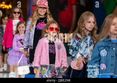 Moskau, Russland. 5.. Juni 2022. Junge Models zeigen die Kinderbekleidungskollektion der Marke Choupette auf einem Podium während der Modenschau „Circus“ im Moskauer Kindergeschäft im Rahmen der Feier des 65.-jährigen Jubiläums des Geschäfts, Russland Stockfoto