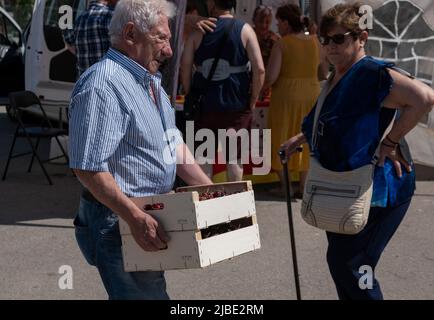 Terrades, Spanien. 05.. Juni 2022. Ein älterer Mann wird gesehen, wie er zwei Kisten voller Kirschen trägt. Nachdem die XXV Fira Mercat de la cirera (Kirschenmesse) wegen Covid-19 für zwei Jahre in Folge ausgesetzt wurde, fand sie wieder in Terrades, Girona, statt. (Foto von Paco Freire/SOPA Images/Sipa USA) Quelle: SIPA USA/Alamy Live News Stockfoto