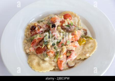 Nahaufnahme von Hummerravioli mit Tomaten und Sahnesauce Stockfoto