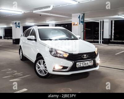 Moskau. Russland. 15. September 2021. Moderne schöne russische Auto Lada Vesta SW. Ein weißer Kombi in einem leeren, mehrstöckigen Parkhaus in der Nacht. Stockfoto