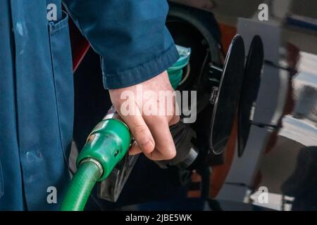 Tankstellenwärter, der bleifreies Benzin in ein Auto auf dem Vorplatz abgibt. Ansicht schließen. In Großbritannien ist der Service der Aufsichtsperson heutzutage selten Stockfoto