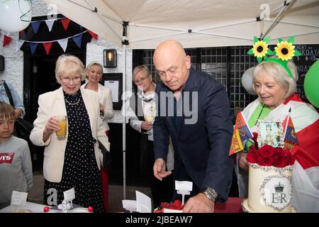 Cookham, Bergen, Großbritannien. 5.. Juni 2022. Die Bewohner und ihre Familien und Freunde hatten heute viel Spaß bei der Cookham Jubilee Street Party in der Stadt. Zu ihnen kamen die Schauspielerin Wendy Craig (links), der Schauspieler und Journalist Ross Kemp sowie die Bürgermeisterin des Royal Borough of Windsor und Maidenhead, Cllr Christine Bateson, die den besten Kuchen beurteilten. Die Kuchen wurden dann verkauft, um Geld für die Thames Hospice Charity zu sammeln. Quelle: Maureen McLean/Alamy Live News Stockfoto