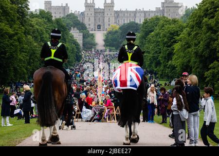 Windsor, Großbritannien. 5.. Juni 2022. Berittene Polizisten nähern sich den Anwohnern, die an einem „Platinum Jubilee Big Lunch“ auf dem Long Walk in Windsor teilnehmen Stockfoto
