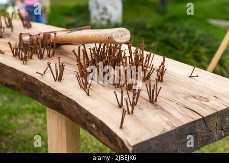 Ein unordentlicher Haufen rostiger Nägel und Hämmer auf einem Holzbrett Stockfoto