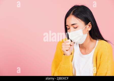 Asiatische schöne junge Frau trägt medizinische Maske Schutz zur Infektion Coronavirus verhindern, COVID-19 Sie husten niesen, Studio Schuss isoliert auf rosa Stockfoto