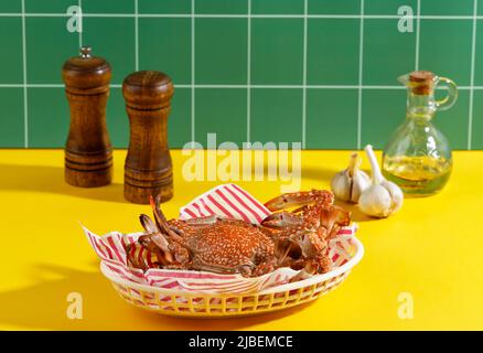 Gedämpfte Blumenkrabbe oder Rajungan, beliebt als Blaue Krabbe, auf gelbem Hintergrund, Restaurant-Menü-Konzept Stockfoto