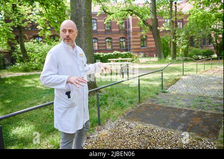 Berlin, Deutschland. 10.. Mai 2022. Torsten Kratz, Facharzt für Neurologie, Psychiatrie und gerontologische Psychiatrie, spricht im grünen Behandlungsraum des Evangelischen Krankenhauses Königin Elisabeth Herzberge darüber, wie Gartentherapie helfen kann. (To dpa 'Graben, Jäten, Pflanzen: Gartentherapie ohne Medikamente') Quelle: Annette Riedl/dpa/Alamy Live News Stockfoto