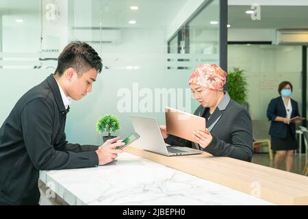 Bürokaufleute, die arbeiten - auf Laptop, Tablet und Smartphone. Stockfoto