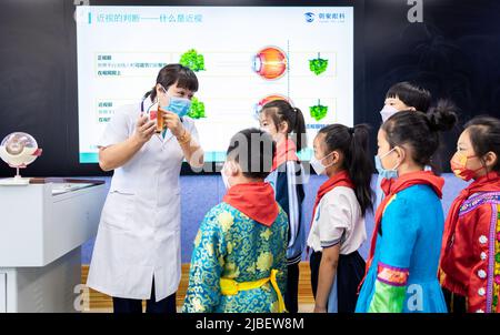 HOHHOT, CHINA - 6. JUNI 2022 - der Augenarzt Yu Fengjuan erklärt Studenten der Nanchaihuo Shijie Primary School in Yuquan Distr die Augenheilkunde Stockfoto