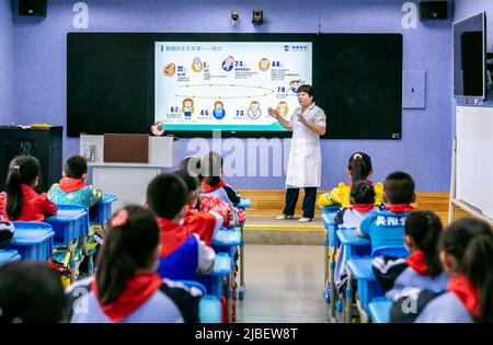 HOHHOT, CHINA - 6. JUNI 2022 - der Augenarzt Yu Fengjuan erklärt Studenten der Nanchaihuo Shijie Primary School in Yuquan Distr die Augenheilkunde Stockfoto