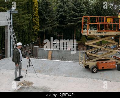 Geodätische Werke. Vermessungsingenieur mit geodätischen Geräten auf der Baustelle. Professionelle Ausrüstung für den Bau. Arbeit als Vermesser. Optisch Stockfoto