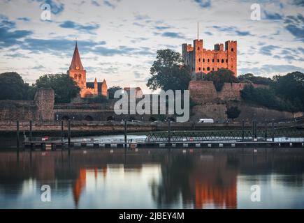 Rochester, Vereinigtes Königreich - 5. August 2015: Letzte Sonnenstrahlen Höhepunkte Rochester Castle und Cathedral. Hoch sichtbarer Abendhimmel und Reflexion auf riv Stockfoto