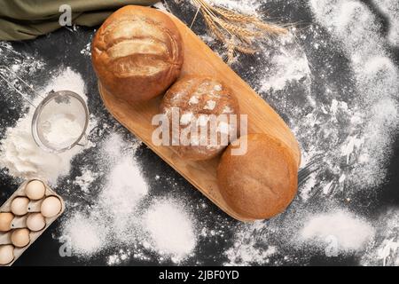 Drei runde Naturbrote mit Weizen- und Roggenmehl. Verschiedene Backwaren in der Bäckerei. Blick von oben. Stockfoto