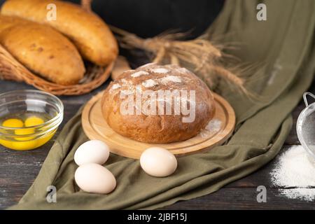 Köstliches frisch gebackenes Brot auf rustikalem Hintergrund Stockfoto