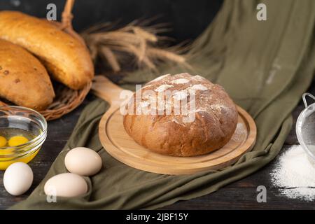 Köstliches frisch gebackenes Brot auf rustikalem Hintergrund Stockfoto