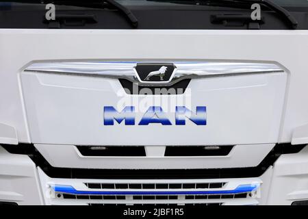 Logo-MANN vor einem neuen, weißen MAN TGX 26,510 schweren Lkw. Einige Regentropfen auf dem Kühlergrill des Staplers. Salo, Finnland. 29.Mai 2022. Stockfoto