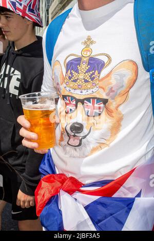 Männlich mit Bier und Queens Jubilee Corgi Krone T-Shirt während Platin Jubiläum in London, Großbritannien. Stockfoto