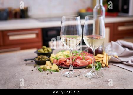 Zwei Gläser Weißwein mit italienischer Antipasto-Fleischplatte auf dem Hintergrund Stockfoto