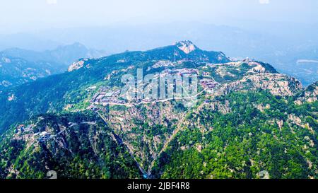 (220606) -- JINAN, 6. Juni 2022 (Xinhua) -- Luftfoto vom 24. Mai 2022 zeigt die Landschaft des Berges Taishan in der ostchinesischen Provinz Shandong. Der Berg Taishan ist eine große und beeindruckende Felsmasse, die sich auf über 1.500 Meter erhebt und wo anmutige Brücken, Tore oder Pavillons mit Pinienwäldern oder felsigen Klippen kontrastieren. Er gilt als einer der schönsten Orte Chinas und als Symbol für alte chinesische Zivilisationen und Glaubensrichtungen. In der östlichen Provinz Shandong gelegen, beherbergt der Berg Taishan mehr als 18.000 alte und kostbare Bäume sowie über 300 Arten von Wildvögeln. Stockfoto