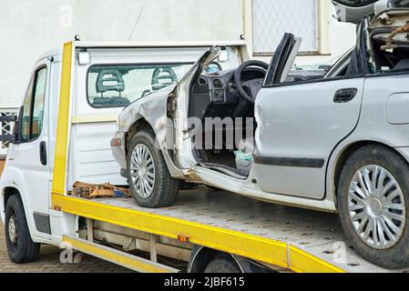 Zerstörte Autoverladung auf Abschleppwagen nach Unfall, Konzept des gefährlichen Fahrens nach Alkoholkonsum, Pannenhilfe Konzept Stockfoto